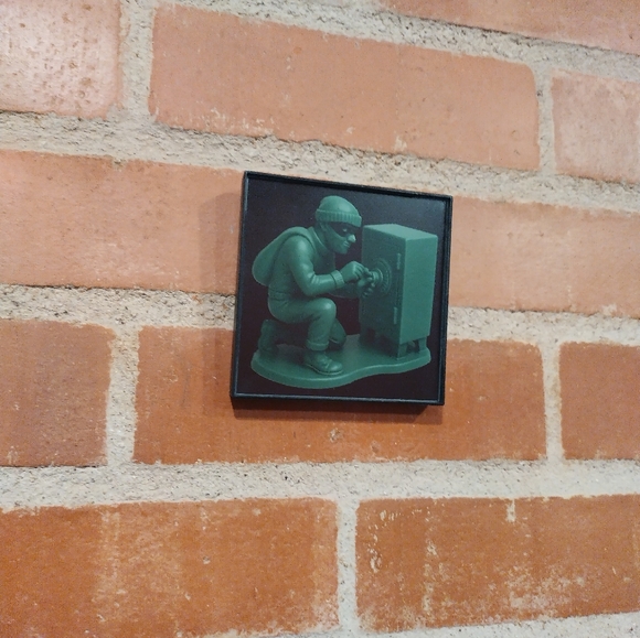 Other - Burglar Cracking Safe Plastic Army Man Framed Mini Art Print By Neon Nicho
